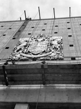 [The Coat of Arms of Canada being positioned on the new post office]