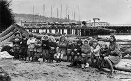 Children and their teacher from Alma House preschool sitting on beach