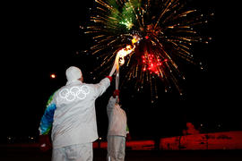 Day 100 Torchbearers pass the flame under a sky of fireworks in Merritt, British Columbia.