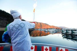 Day 89 Torchbearer 138 Gordon Mackie carries the flame on a houseboat in Sicamous, British Columbia.