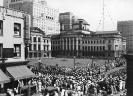 [Crowd watching Vancouver Golden Jubilee parade at Robson and Howe Streets]