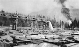 Flume emptying into water full of logs