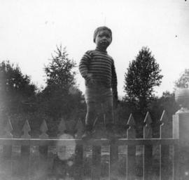 [A boy on a fence at 915 Pacific Street]