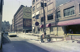 Water Street [Street construction, construction workers, and sign for The Old Spaghetti Factory a...