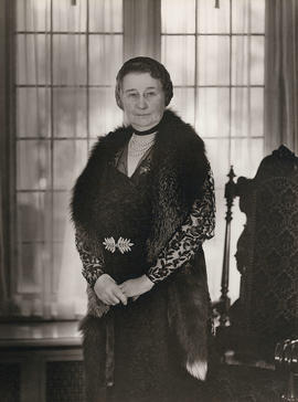 Adaline Hendry standing in fur stole and pearls