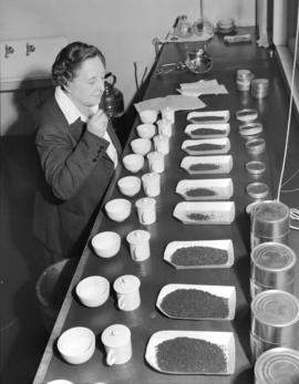 Mrs. Lillico [examining a selection of teas at] Empire Tea Bureau