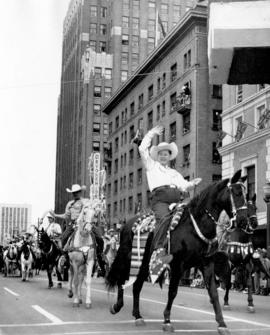 [Mayor McKay of Calgary riding a horse on Georgia Street in the Grey Cup Parade]