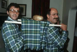 Michael Francis and Mike Harcourt dressed in Centennial tartan carrying the haggis