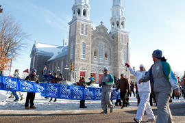 Day 43 Torchbearer carries the flame in front of a church in Saint-Jacques, Ontario.