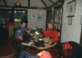 Police officer and Mountie seated in dining room of Brockton Clubhouse during  the Centennial Com...