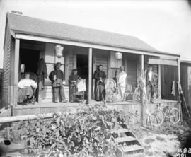 [Stark family and cook assembled on porch of summer cottage at English Bay]