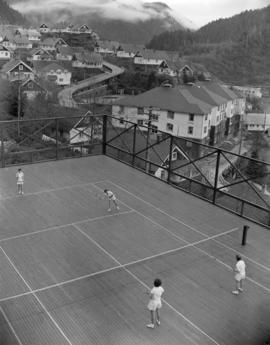 [Four women playing] tennis [at] Pacific Mills