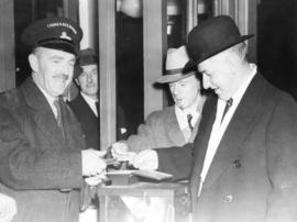 [Major Currie, Manager of the First Narrows Bridge Company punches the first ticket for crossing ...