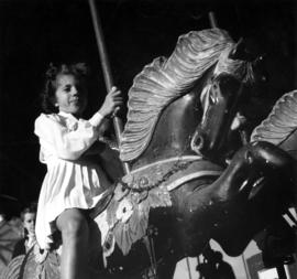 Girl on merry-go-round in P.N.E. Kiddieland