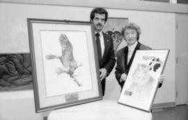 Unidentified man and May Brown holding prints from the Centennial gift program