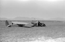 ["Miss Sweet Caporal" airplane being towed by a car]