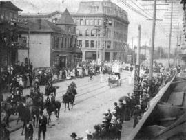 [A Dominion Day parade moving east towards the corner of Hastings Street and Granville Street]
