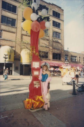 Woman wearing costume standing next to decorated lamp post