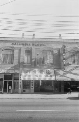 [Storefronts in Columbia Block building at the intersection of Columbia and East Pender Streets]