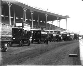 [Fleet of electrically operated trucks assembled on race track at Hastings Park]