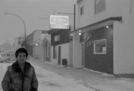 Young man standing at the site of Gordon Yee's café on Centre Street in Naicam, Saskatchewan