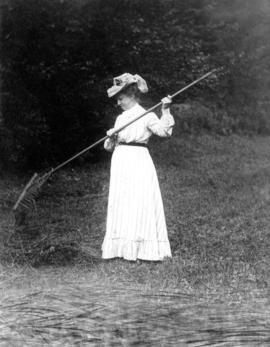 [Caroline Little Pierce raking grass]