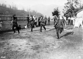 [Scottish Regiment Band members race while playing instruments]