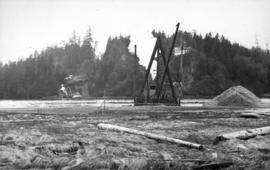 Dredge getting depth on North Shore for basin for anchorage scows carrying building material