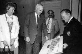 Unidentified man showing framed print to awards attendees