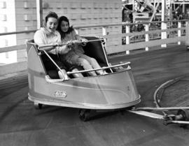 Girls on "The Whip" amusement ride in P.N.E. Gayway