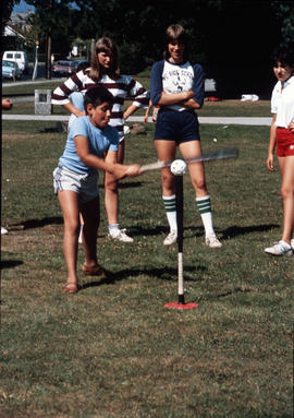 [Boy hitting ball off baseball batting tee]