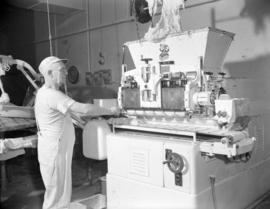 [Man operating a bread dough machine]