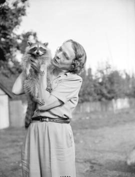 [Mrs. Charles Winfield holding a tame raccon at Bowser on Vancouver Island]