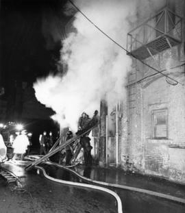 [Firefighters on ladders battling brick building blaze at 808 West Pender Street]