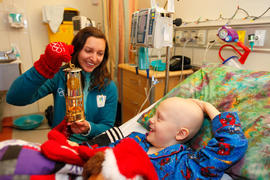 Day 52 Kelly Simpson shows Lyric Jarvis the Olympic Flame inside the lantern at Children's Hospit...
