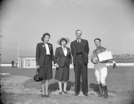 [Group portrait of a jockey (possibly Emil Sporri) with two women and man at a race track]