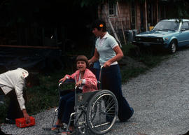Girl pushing girl in wheelchair at Camp Capilano