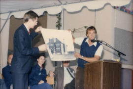 Two men holding up drawing at podium