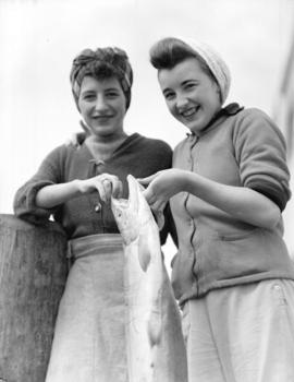 Cannery workers [holding a] salmon