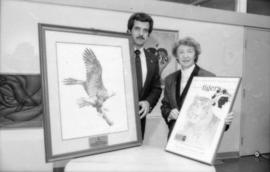 Unidentified man and May Brown holding prints from the Centennial gift program