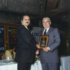 Robert Gordon Rogers delivering plaque to man at Kiwanis Club Centennial luncheon