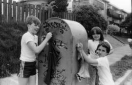 Troy Zwolinski, Jasmine Gibbons and David LeBrun clean graffiti off mailbox