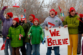 Day 75 Group of kids cheer on the flame with signs and flags as it passes in Saskatchewan.