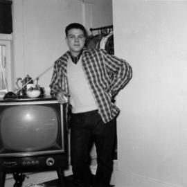 Unidentified man leaning on television