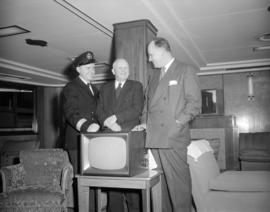 [C.N.R. employee with two men standing behind a television as part of an event associated with th...