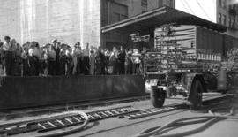 [Crowd watching tower ladder fire wagons at work at a C.P.R. loading area]