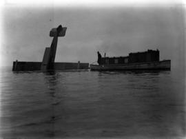 [Seaplane partially submerged in harbour and salvage boat]