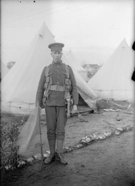 [Soldier in front of a tent]