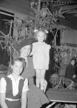 [Portrait of a woman with children at a Christmas party]