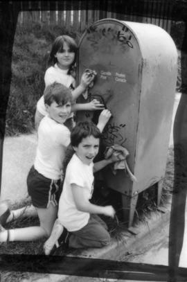 David LeBrun, Troy Zwolinski and Jasmine Gibbons clean graffiti off mailbox